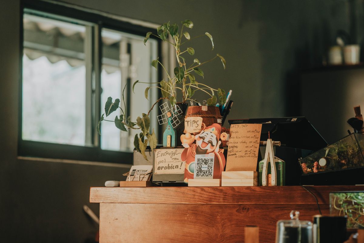 Display com QR Code no balcão do caixa de uma loja, ao lado da máquina registradora · Foto: FOX / Pexels (licença Pexels, uso comercial livre)