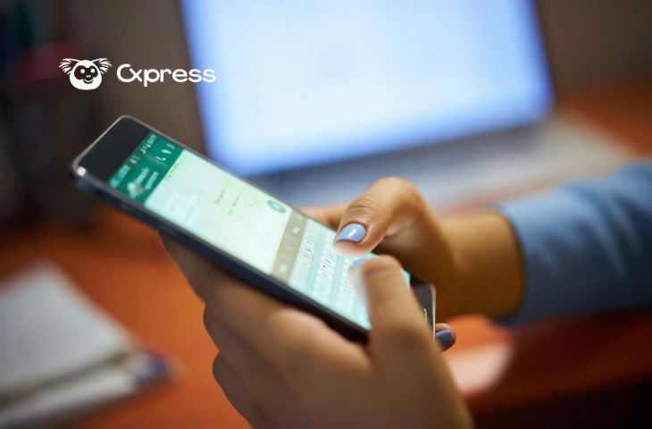 Banimento no WhatsApp: Pessoa usando WhatsApp Business no celular em ambiente de trabalho