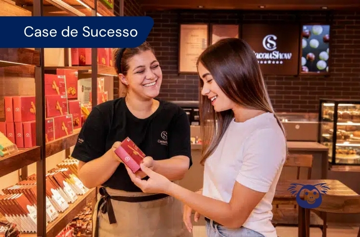 Atendente da Cacau Show apresenta um produto a uma cliente em loja, no case de atendimento com IA da Cxpress