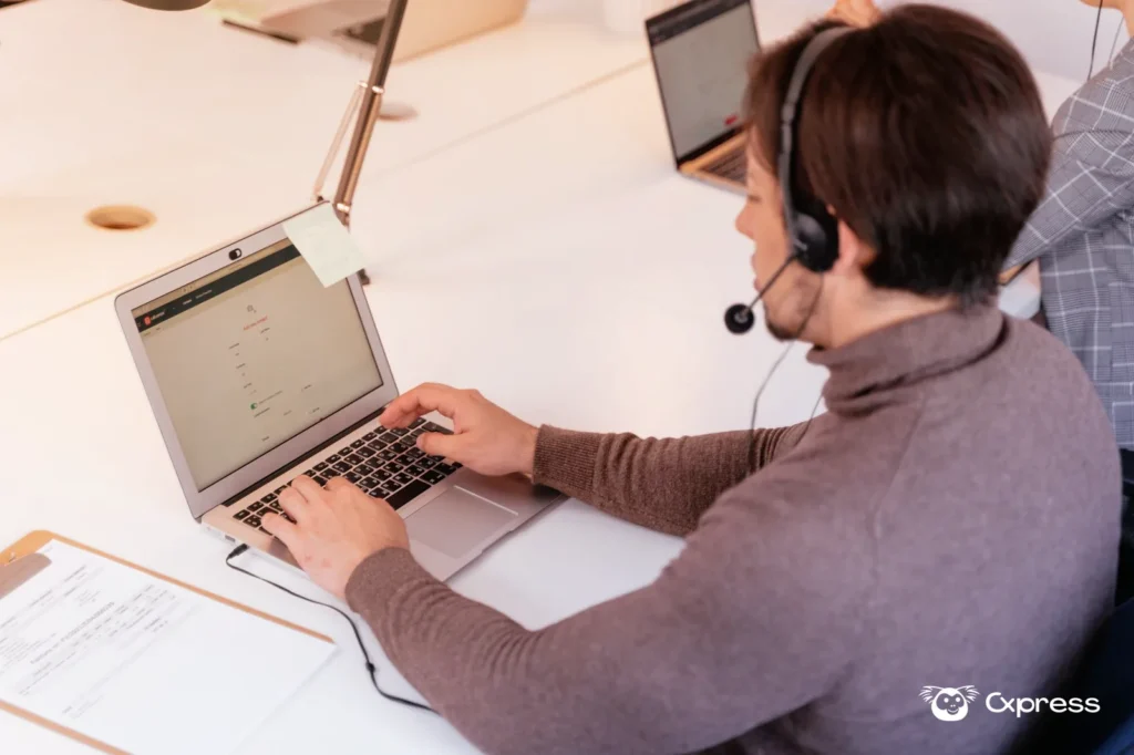 Pessoa acompanhando um dashboard de atendimento ao cliente em um notebook com mensagens abertas na tela