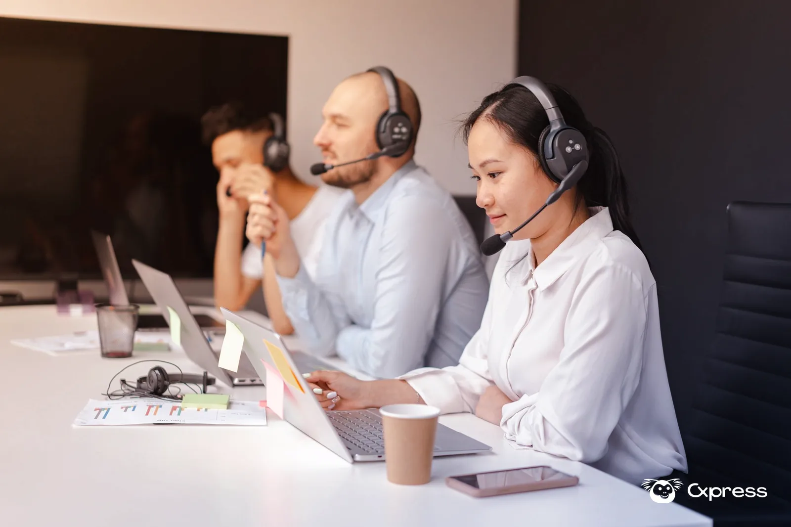 Equipe de suporte analisando mensagens de clientes em notebooks durante a triagem de atendimento