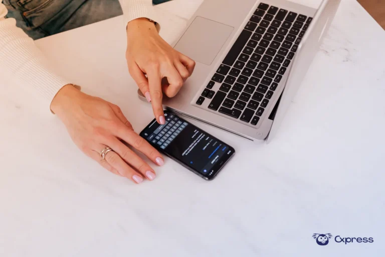 Mesa de atendimento com telefone, celular com mensagens e notebook aberto para gestão de telefone e WhatsApp